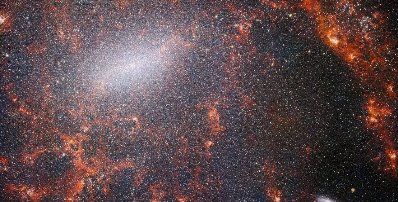 这张NGC 5068由韦伯太空望远镜NIRCam拍摄,此星系被大量的恒星群所包围,其中最密集的是沿着其明亮的中央棒状,以及被内部年轻恒星照亮的红色气体云。This view of NGC 5068, from Webb’s NIRCam instrument, is studded by the galaxy’s massive population of stars, most dense along its bright central bar, along with burning red clouds of gas illuminated by young stars within. Image credit: NASA / ESA / CSA / Webb / J. Lee / PHANGS-JWST Team.