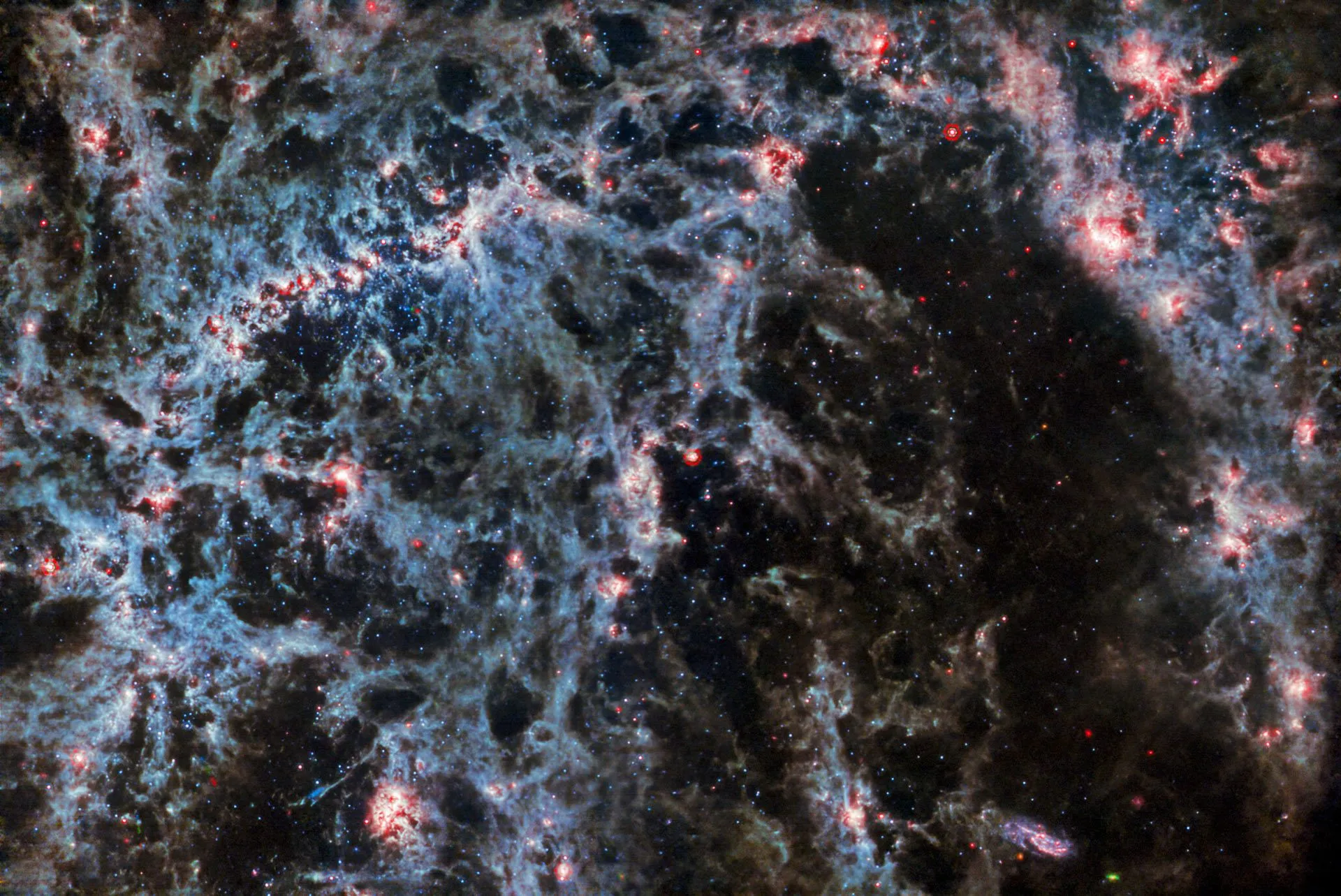这张NGC 5068由韦伯太空望远镜MIRI拍摄,其尘埃结构和包含新形成星团的发光气体气泡特别明显。In this image of NGC 5068, from Webb’s MIRI instrument, the dusty structure of the spiral galaxy and glowing bubbles of gas containing newly-formed star clusters are particularly prominent. Three asteroid trails intrude into this image, represented as tiny blue-green-red dots. Image credit: NASA / ESA / CSA / Webb / J. Lee / PHANGS-JWST Team.